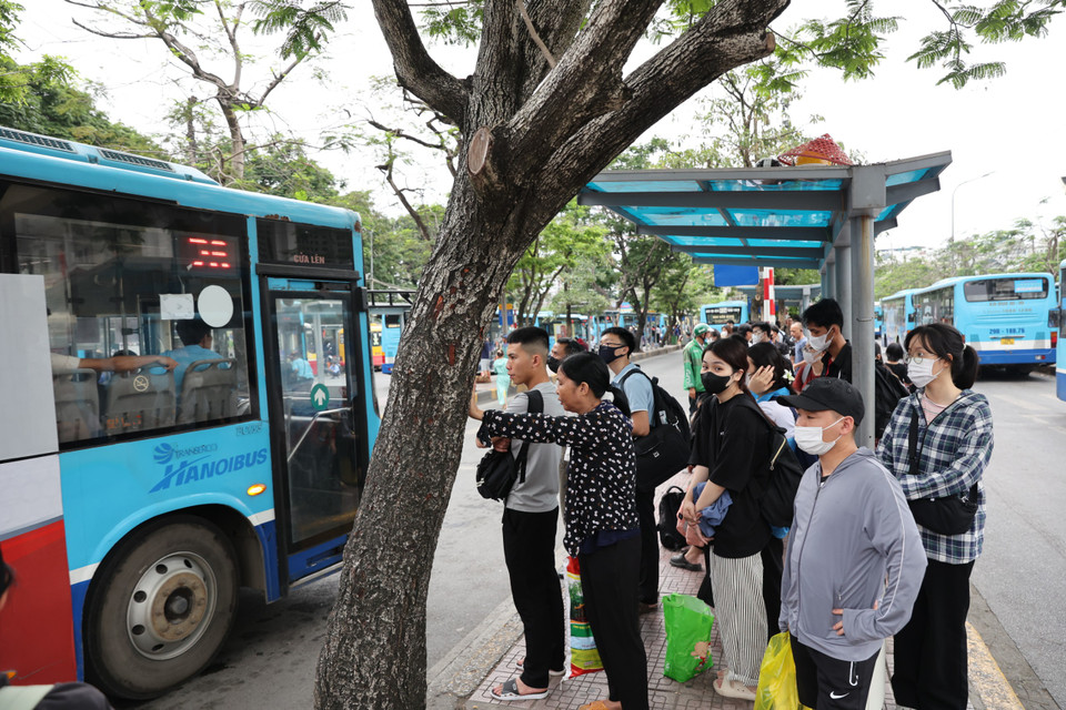 Nhiều phương tiện chở khách đi qua nhưng cũng không thể mở cửa đón bởi đã quá đông hành khách. (Ảnh: Tuấn Anh/Vietnam+)