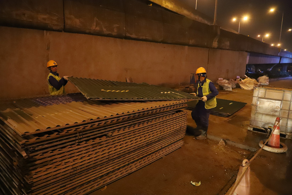 23 giờ đêm 2/2, khu rào chắn thi công cuối cùng thuộc gói thầu số 2 - dự án hệ thống xử lý nước thải Yên Xá (Hà Nội) trên đường Nguyễn Xiển được công nhân tháo dỡ. (Ảnh: Hoài Nam/Vietnam+)