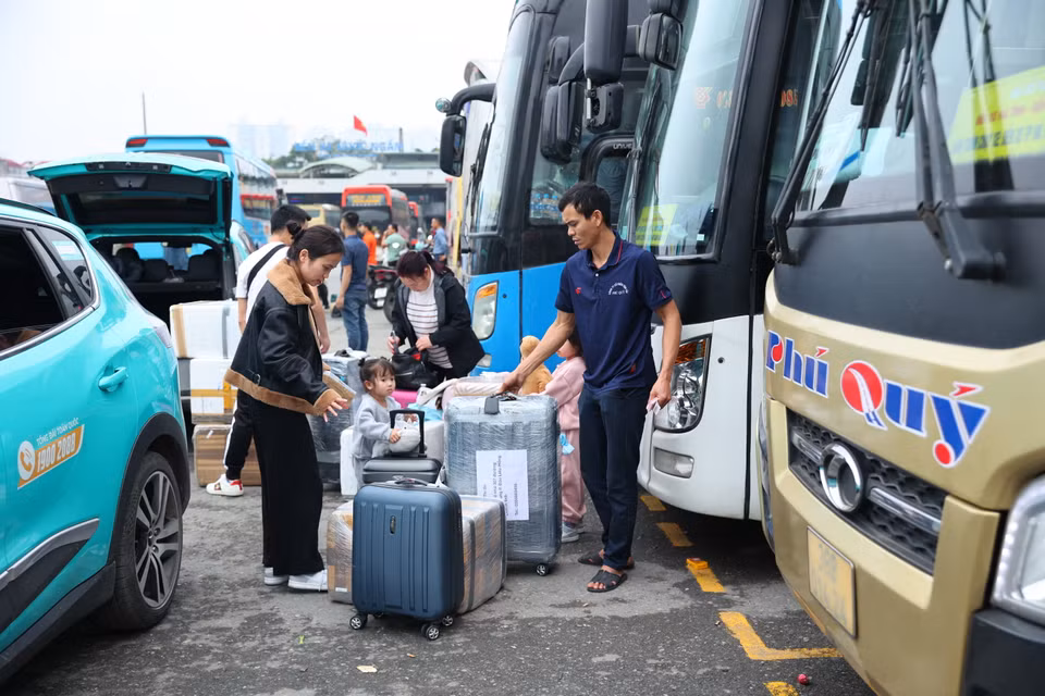 Một số người từ nước ngoài về quê ăn Tết nên tranh thủ từ sân bay Nội Bài về thẳng bến xe. (Ảnh: Hoài Nam/Vietnam+)