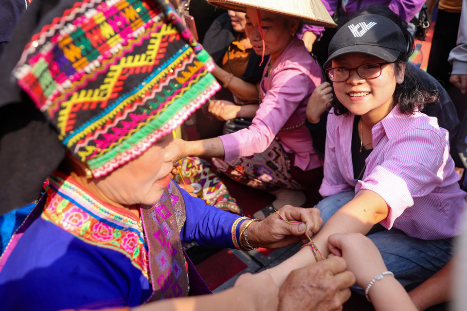 Trong lễ hội này, ai càng được buộc nhiều chỉ ở cổ tay thì càng may mắn. Để thể hiện lòng mến khách của người dân địa phương, những chiếc vòng may mắn thường dành tặng riêng cho khách đến thăm bản. (Ảnh: Hoài Nam/Vietnam+)
