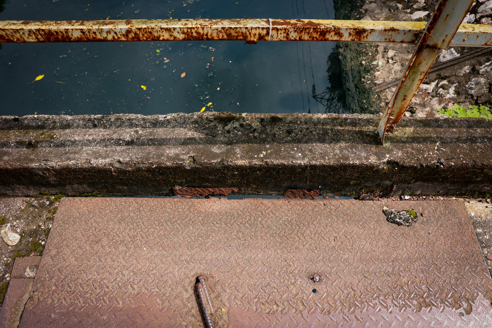 Hiện trạng mặt cầu chắp vá tạm bợ bằng tấm kim loại, tuy nhiên những mảnh vá này cũng đã hoen gỉ, xuống cấp. (Ảnh: Hoài Nam/Vietnam+)