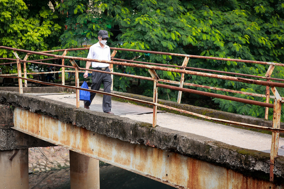 Người dân hằng ngày vẫn phải di chuyển qua cây cầu đã xuống cấp này. (Ảnh: Hoài Nam/Vietnam+)
