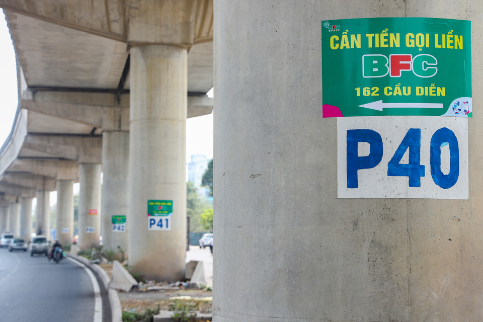 Những trụ bê tông nâng đỡ tuyến đường sắt được 'tận dụng' làm nơi dán quảng cáo. Dù việc này không ảnh hưởng tới chất lượng công trình nhưng gây mất mỹ quan đô thị. (Ảnh: Hoài Nam/Vietnam+)