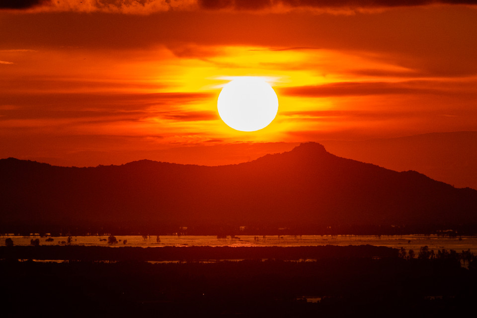 Hoàng hôn buông xuống, Mặt Trời như quả cầu lửa rơi dần, dát ánh vàng cam trên bầu trời. Đó cũng là lúc đồng bằng tối dần, nhường chỗ cho cái ráng chiều đỏ rực phía trời Tây. (Ảnh: Hoài Nam/Vietnam+)