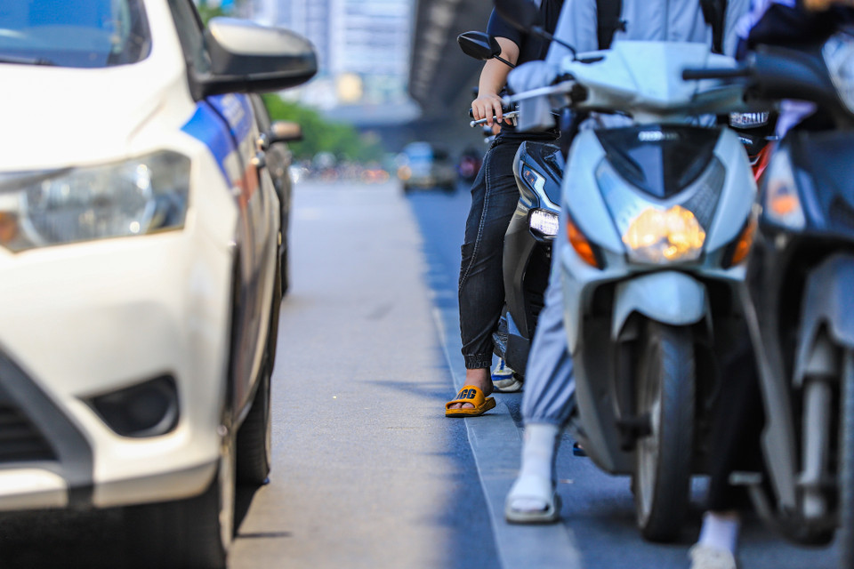Xe máy xếp hàng dừng đèn đỏ tại khu vực có bóng râm trên đường Minh Khai. (Ảnh: Hoài Nam/Vietnam+)