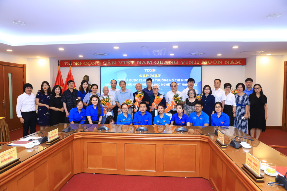 Các nghệ sĩ nhiếp ảnh chụp ảnh lưu niệm cùng Ban lãnh đạo và Đoàn thanh niên TTXVN sau buổi giao lưu. (Ảnh: Hoài Nam/Vietnam+) 