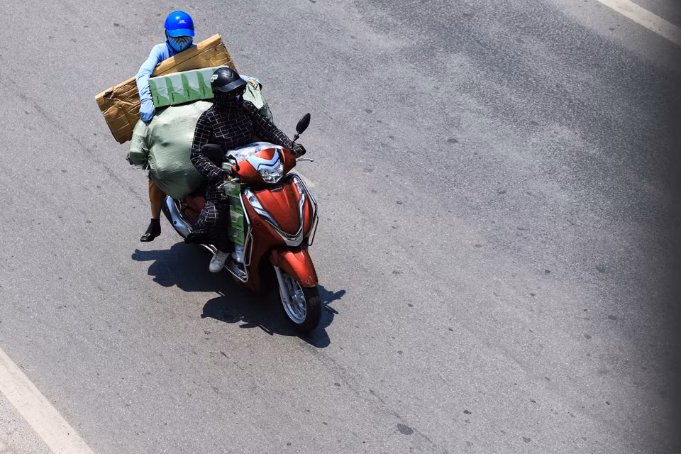 Tuy nhiên, vì đặc thù công việc nên một số người dân vẫn phải di chuyển trên mặt đường như chảo lửa giữa buổi trưa. (Ảnh: Hoài Nam/Vietnam+)