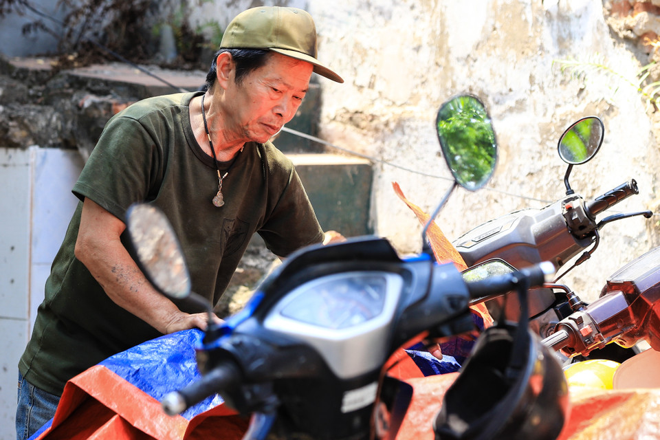 Anh Hùng trông coi xe tại một quán ăn trên đường Đại La thường xuyên phải làm việc vào khoảng thời gian 11 giờ đến 13 giờ chia sẻ: ‘Thời tiết nắng nóng rất khó chịu, mặc dù ngồi dưới bóng cây nhưng hơi nóng dưới mặt đường bốc lên rất ngột ngạt.’ (Ảnh: Hoài Nam/Vietnam+)