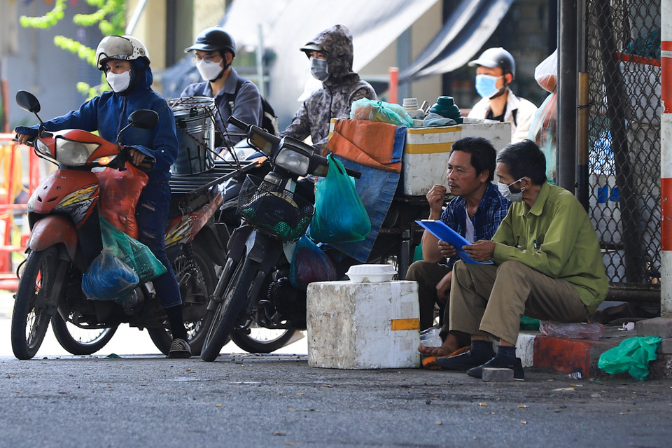 Họ thường tập trung ở những nơi có tán cây to, nhà cao tầng để tận dụng bóng râm che bớt nắng tranh thủ nghỉ trưa. (Ảnh: Hoài Nam/Vietnam+)