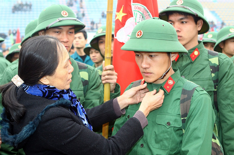 Người mẹ bùi ngủi sửa lại vai áo cho con trước giờ lên đường (Ảnh: Trọng Đức - TTXVN)
