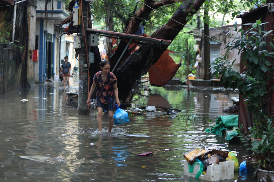 Người dân 'bì bõm' dọn rác sau cơn bão. (Ảnh: Hoài Nam/Vietnam+)
