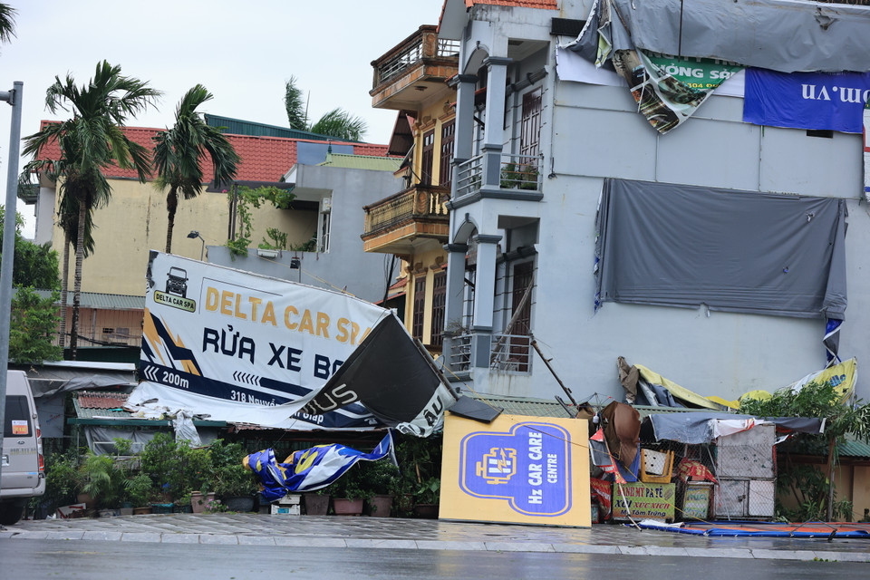 Biển hiệu của cửa hàng trên phố Trịnh Văn Bô (Nam Từ Liêm) bị gió làm hư hỏng. (Ảnh: Hoài Nam/Vietnam+)