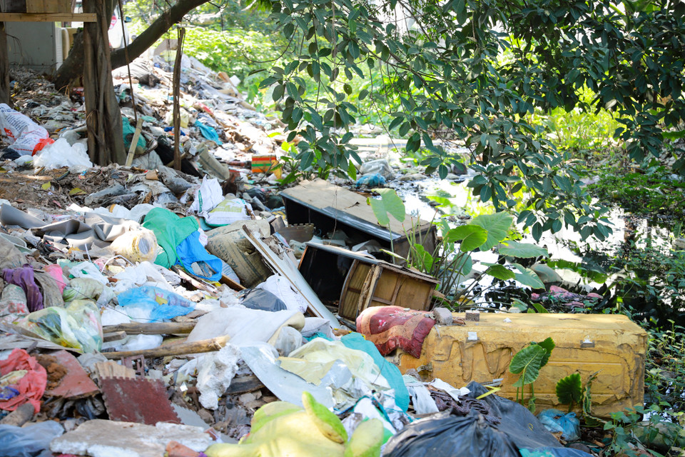 Rác thải đủ thể loại chất đầy ven bờ và dưới lòng mương. Người dân khu vực này cho biết vào những ngày mưa lớn nước không thoát kịp, nơi đây trở thành một con ngõ rác trôi nổi. (Ảnh: Hoài Nam/Vietnam+)