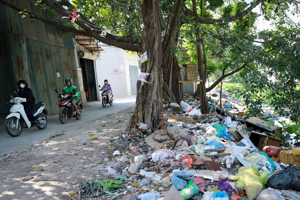 Cách đó không xa là ‘dòng sông rác’ thuộc con ngõ 298 Trần Điền. Đây là khu vực thuộc quy hoạch của dự án Vành đai 2,5. Do dự án chậm tiến độ lâu ngày nên khu vực trở thành điểm đổ trộm rác thải. (Ảnh: Hoài Nam/Vietnam+)