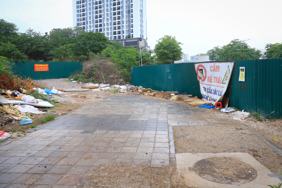 Một đoạn vỉa hè trên tuyến đường này bị chặn cứng bởi lô cốt tôn và trở thành điểm tập kết rác thải, người dân hoàn toàn không thể sử dụng được vỉa hè khu vực này. (Ảnh: Hoài Nam/Vietnam+)
