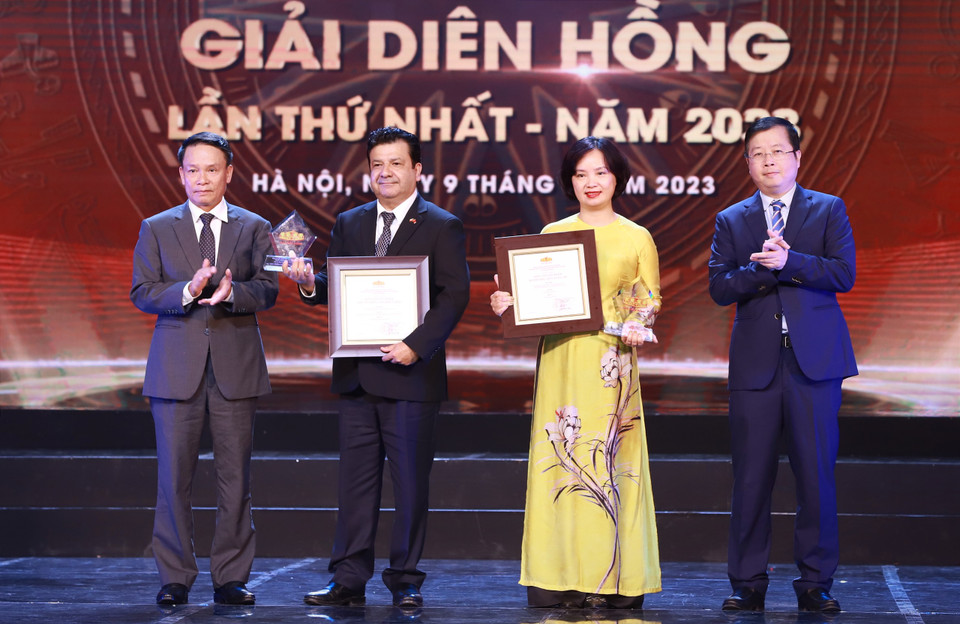 Ông Nguyễn Thanh Lâm, Thứ trưởng Bộ Thông tin và Truyền thông (bìa phải), ông Nguyễn Đức Lợi, Phó Chủ tịch Thường trực Hội Nhà báo Việt Nam (bìa trái) trao giải Sản phẩm đa phương tiện xuất sắc cho đại diện Thông tấn xã Việt Nam. (Ảnh: Hoài Nam/Vietnam+)
