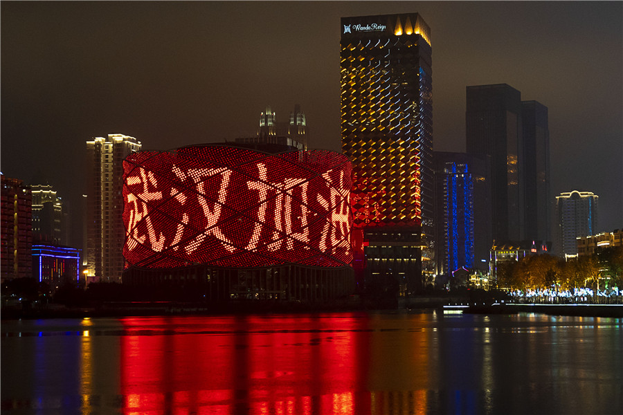 Một tòa nhà ở Vũ Hán bật đèn chiếu dòng chữ "Vũ Hán cố lên", khẩu hiệu phổ biến trong cuộc chiến chống virus corona (Ảnh: Chinadaily)