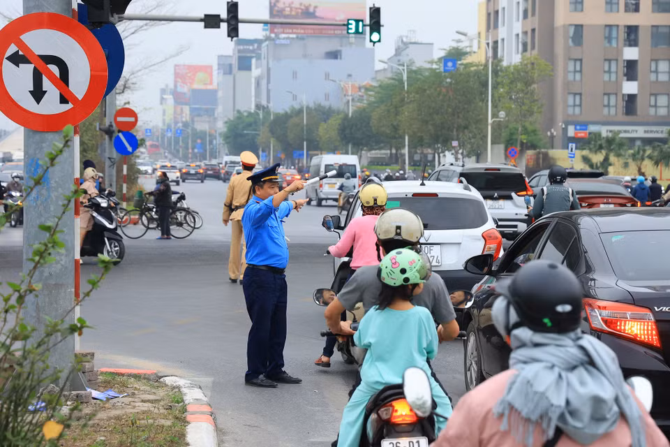 Lực lượng chức năng vừa tuyên truyền vừa hướng dẫn người dân di chuyển theo hướng điều chỉnh mới. (Ảnh: Hoài Nam/Vietnam+)