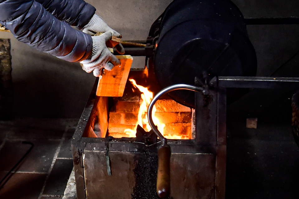 Thợ rang càphê phải thật tinh tế trong khâu cảm nhận độ nóng của bếp củi, khi nhiệt đủ nóng thì mới bắt đầu bỏ hạt vào rang. (Ảnh: Hoài Nam/Vietnam+)