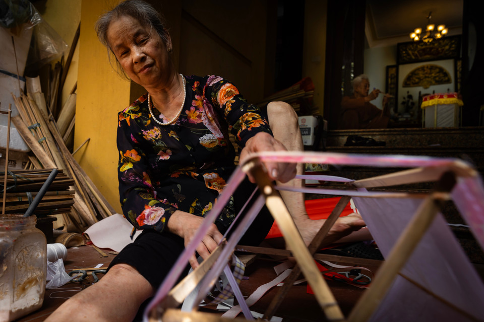 Xung quanh khung đèn sẽ được dán giấy nến hoặc giấy bản để in bóng 'quân' khi thắp nến bên trong. (Ảnh: Hoài Nam/Vietnam+)