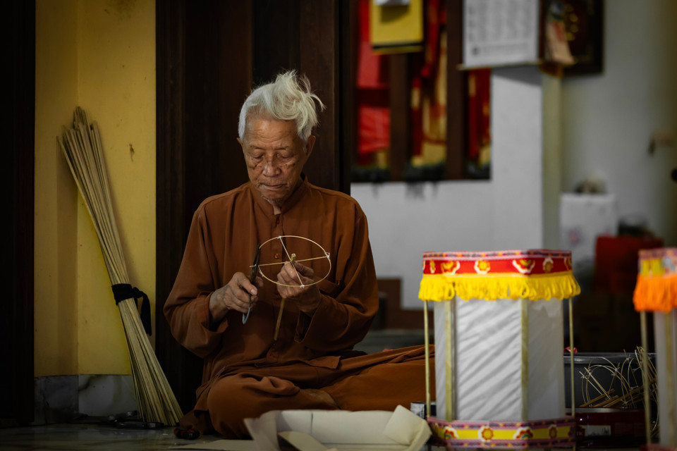 Ở tuổi 85, nghệ nhân Nguyễn Văn Quyền vẫn còn rất nhanh nhẹn. Ông Quyền kể, khi còn nhỏ, cứ đến dịp Tết Trung thu, các cụ trong nhà lại làm đèn cho con cháu chơi. (Ảnh: Hoài Nam/Vietnam+)