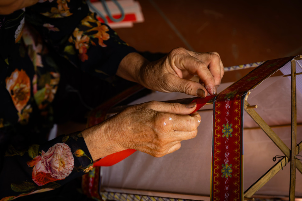 Để tạo thêm thẩm mỹ, bên ngoài chiếc đèn dán thêm những họa tiết trang trí nhỏ để chiếc đèn nhìn sinh động, bắt mắt hơn. (Ảnh: Hoài Nam/Vietnam+)