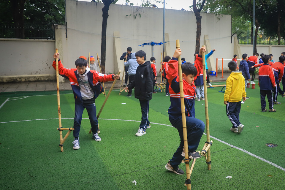 Ngoài ra học sinh còn được “thử thách” với trò chơi cà kheo để rèn luyện sự khéo léo và phối hợp nhịp nhàng tay chân, khả năng giữ thăng bằng. (Ảnh: Hoài Nam/Vietnam+)