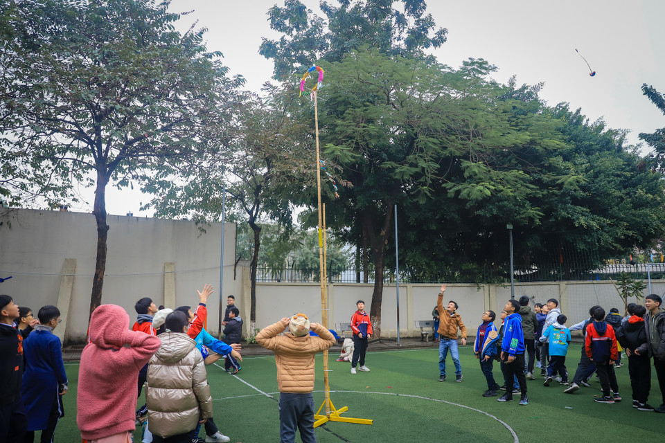 Học sinh trải nghiệm trò chơi ném còn, trò chơi này thường được tổ chức vào mỗi dịp Tết hay lễ hội. Trò chơi thể hiện mong ước về một năm mới mùa màng tươi tốt, vạn vật sinh sôi nảy nở. (Ảnh: Hoài Nam/Vietnam+)