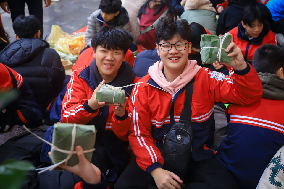 Học sinh lớp 8A3 trường trung học cơ sở Dịch Vọng rất vui vì tự tay gói được bánh chưng. (Ảnh: Hoài Nam/Vietnam+)