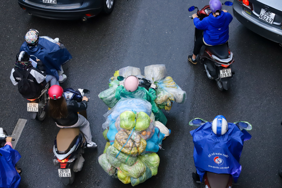 Theo ghi nhận, khoảng 6 giờ 30 sáng, người dân di chuyển trong mưa và trong nền nhiệt thấp. (Ảnh: Hoài Nam/Vietnam+)