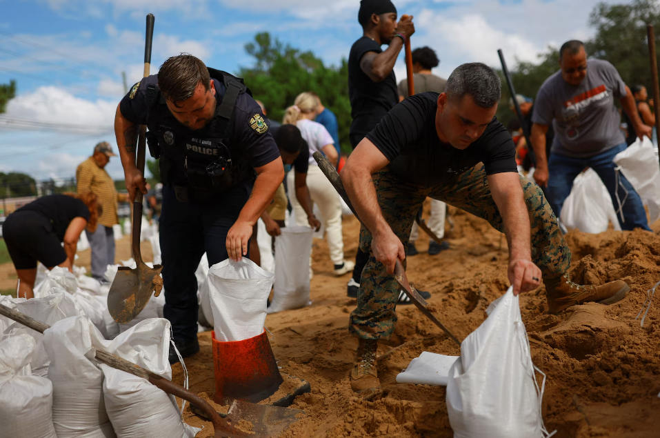 Lực lượng chức năng tham gia gia cố nhà cửa và các công trình (Ảnh: Reuters)