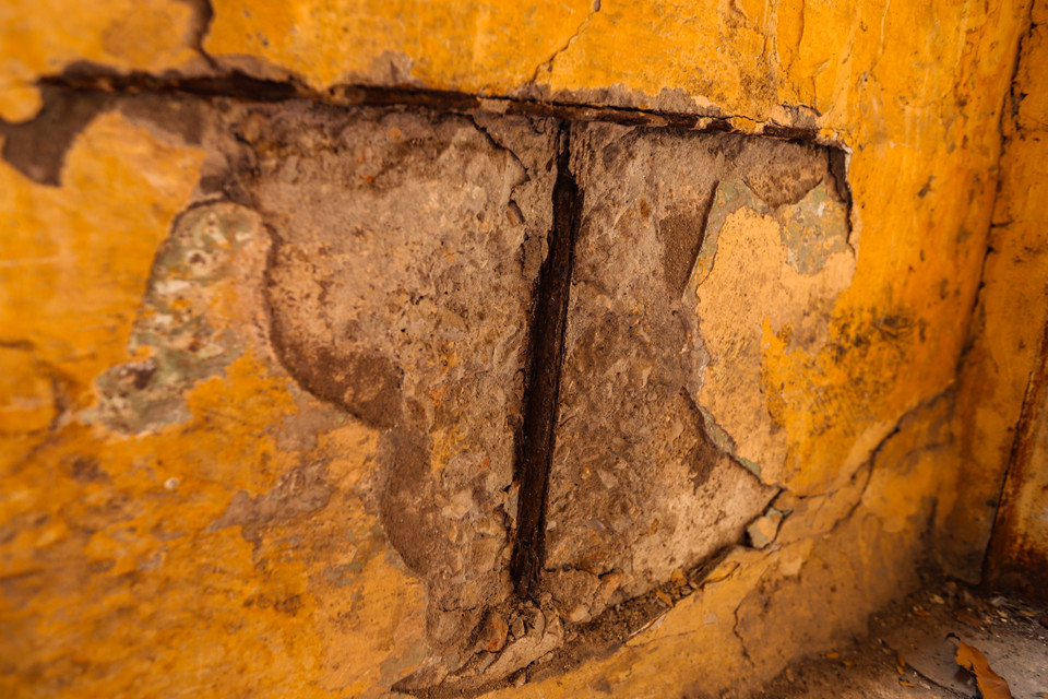 Những mảng tường nứt vỡ, lộ rõ sắt thép bị bong tróc, có thể rơi bất cứ lúc nào, tiềm ẩn nguy cơ mất an toàn. (Ảnh: Hoài Nam/Vietnam+)