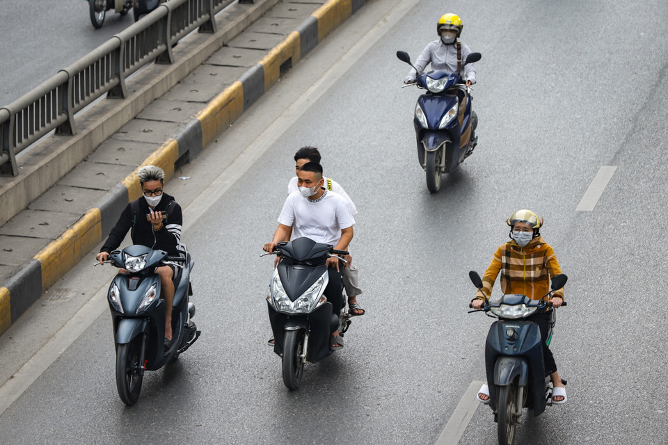 Người tham gia giao thông không đội mũ bảo hiểm, sử dụng điện thoại khi đang điều khiển phương tiện. (Ảnh: Hoài Nam/Vietnam+)