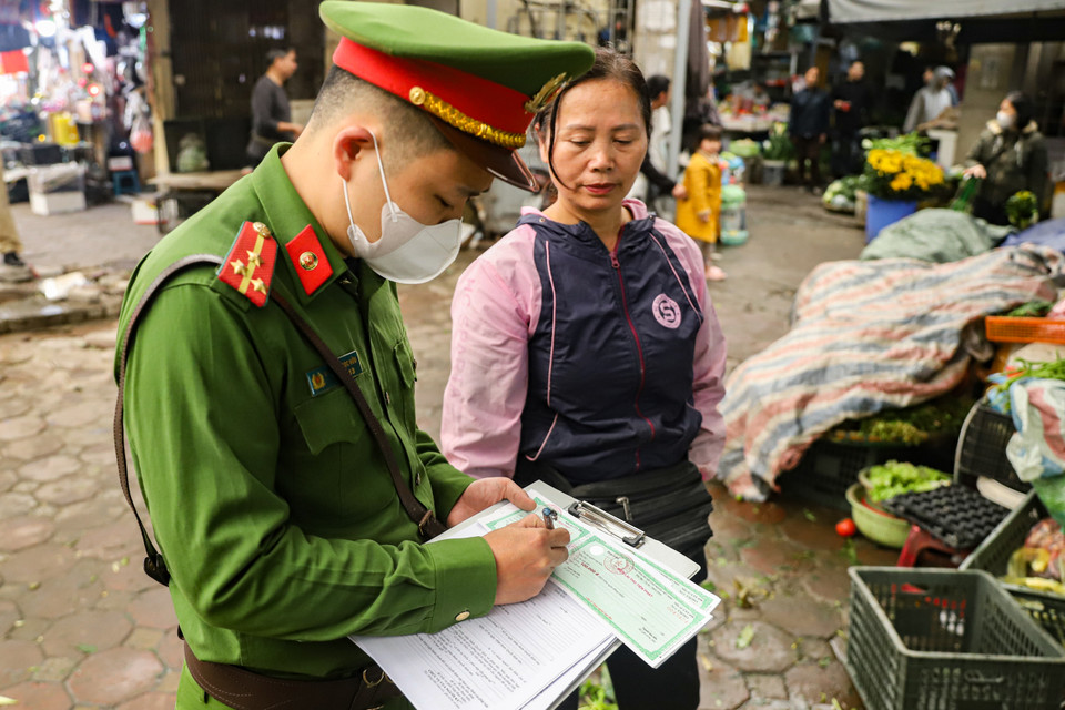 Lực lượng chức năng tiến hành xử phạt hành chính 1 trường hợp vi phạm về đảm bảo trật tự văn minh đô thị tại khu vực chợ Thái Hà. (Ảnh: Hoài Nam/Vietnam+)