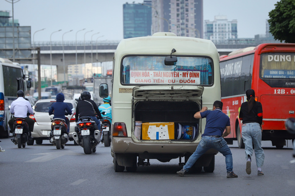 Nhà xe chen nhau, vội vã đón khách, nhận hàng giữa lòng đường Phạm Hùng trước khi vào đường Vành đai 3 trên cao hướng về phía đường Phạm Văn Đồng. (Ảnh: Hoài Nam/Vietnam+)