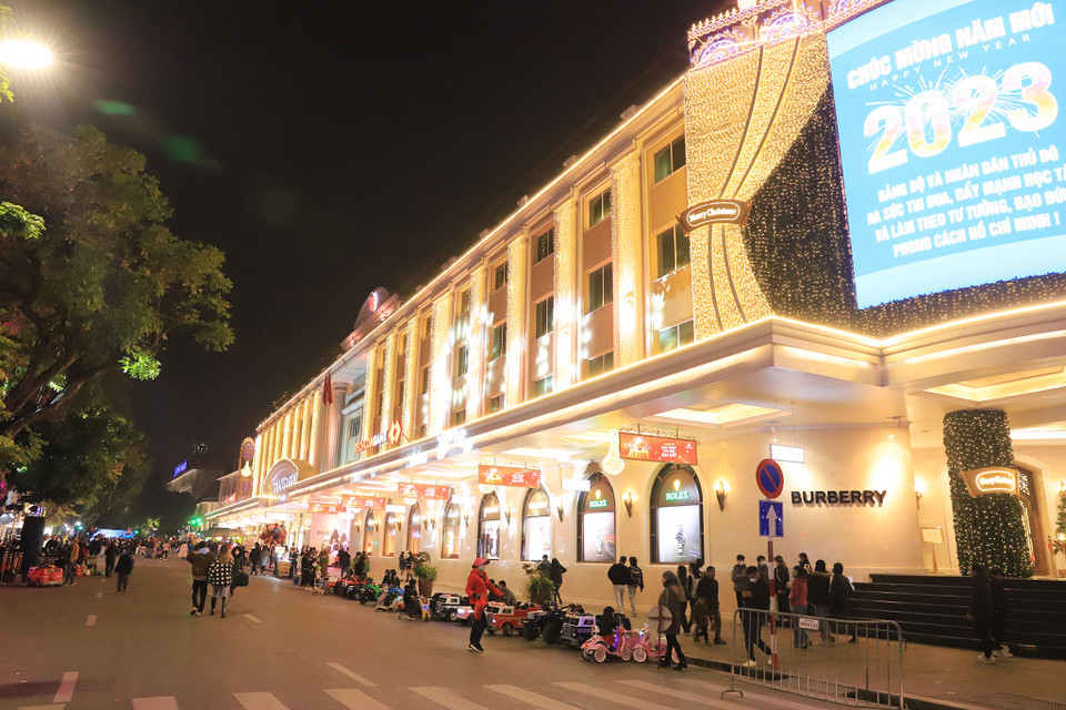 Trung tâm thương mại Tràng Tiền Plaza lung linh trong ánh đèn vàng, biển quảng cáo chúc mừng năm mới. (Ảnh: Hoài Nam/Vietnam+)