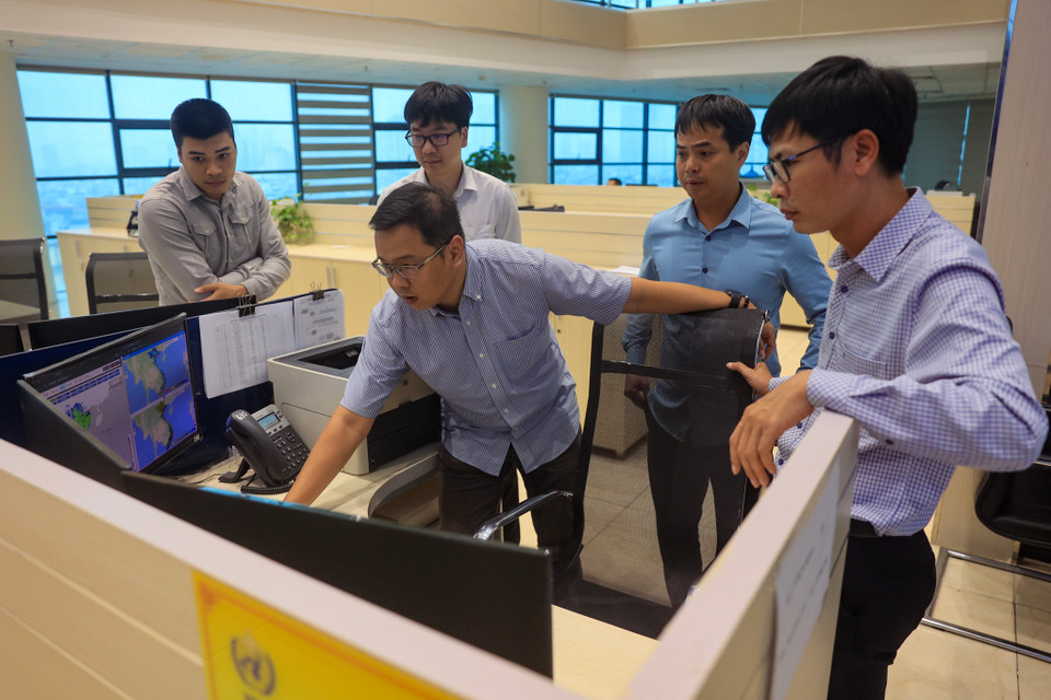 Những gương mặt căng thẳng, tập trung của cán bộ nhân viên đài khí tượng. (Ảnh: Hoài Nam/Vietnam+)