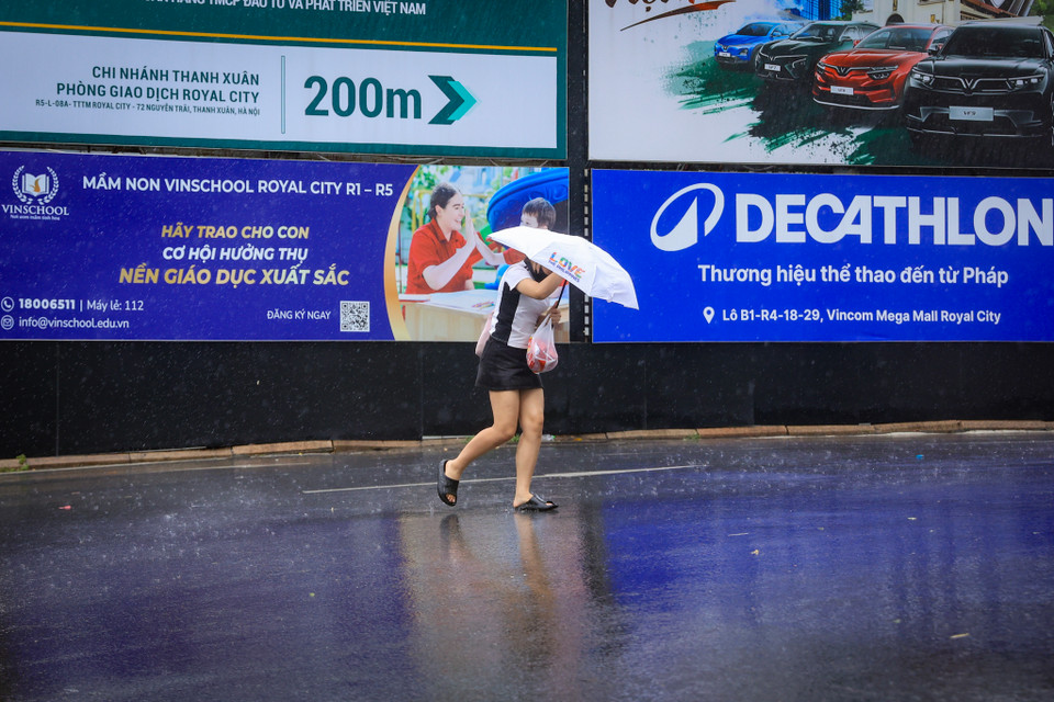 Người đi bộ cũng di chuyển khó khăn vì gió lớn. (Ảnh: Hoài nam/Vietnam+)