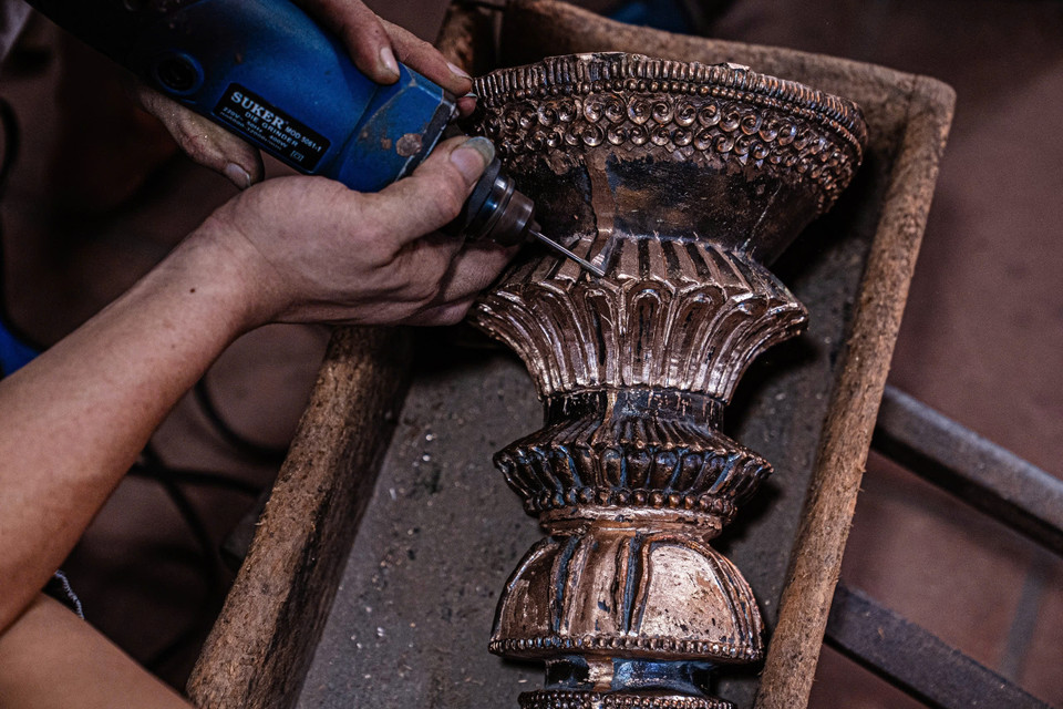 Với đôi bàn tay khéo léo và cảm nhận của người làm nghề, những khối đồng sẽ 'thay da đổi thịt' trước khi được đánh bóng. (Ảnh: Hoài Nam/Vietnam+)