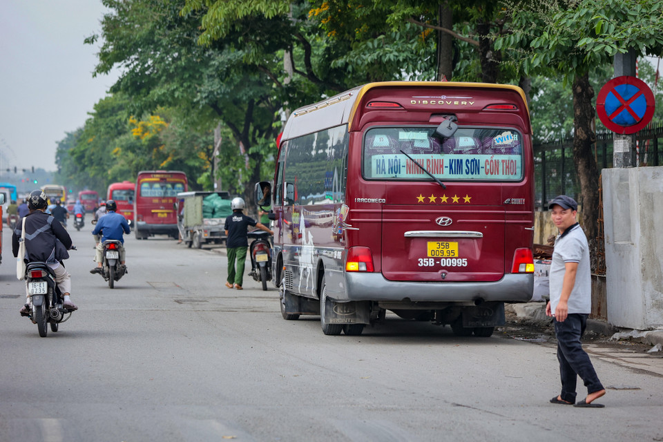 Nhiều nhà xe nối đuôi nhau sau biển cấm dừng cấm đỗ để bắt khách. (Ảnh: Hoài Nam/Vietnam+)