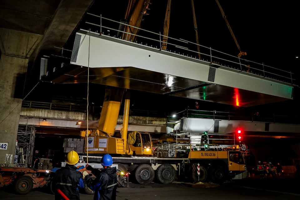 Từng nhịp dầm cầu được công nhân sử dụng cần cẩu 220 tấn để tiến hành lắp đặt. (Ảnh: Hoài Nam/Vietnam+)