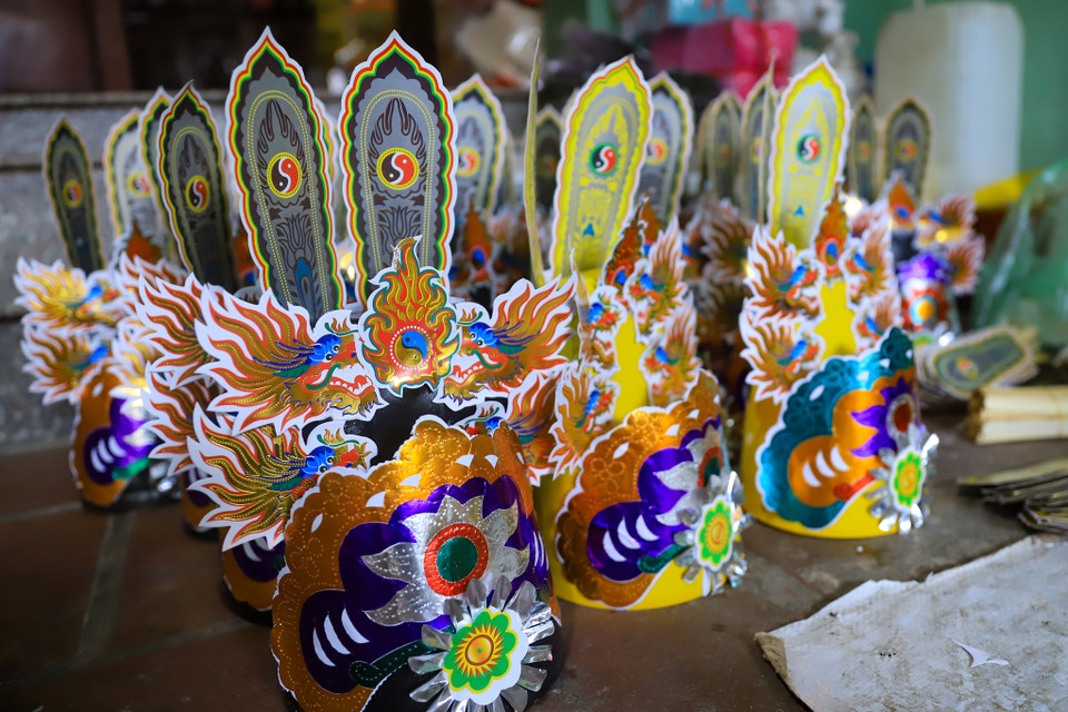 Hộ dân ở đây chia sẻ: "Năm nay mặt hàng mũ ông Công, ông Táo của chúng tôi tiếp tục sản xuất theo sự cải tiến của năm trước là thêm nhiều giấy ánh kim, sản xuất cả hàng cao cấp và hàng bình dân." (Ảnh: Hoài Nam/Vietnam+)