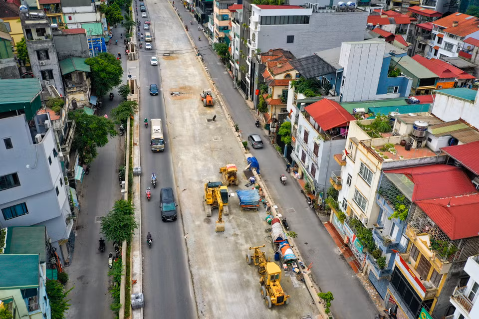 Dự án mở rộng đường Âu Cơ - Nghi Tàm thay thế một phần kết cấu đê đất hữu Hồng bằng tường chắn bê tông cốt thép dạng chữ L, kết hợp mở rộng và hạ thấp mặt đường đê từ 2 làn thành 4 làn xe. Hai bên được cải tạo 2 làn đường dân sinh bên dưới, mỗi bên 5m. (Ảnh: Hoài Nam/Vietnam+)