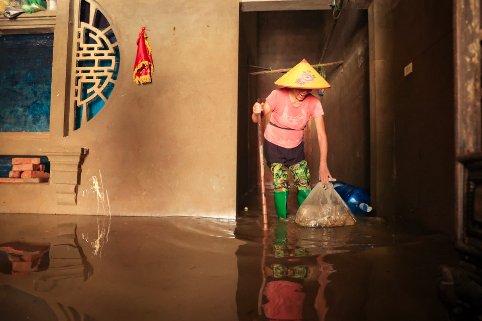 Người dân dọn dẹp theo tinh thần nước rút đến đâu dọn dẹp tới đó khi nước hạ thấp vì trên địa bàn xã Nam Phương Tiến vẫn còn một số nơi nước chưa rút hẳn. (Ảnh: Hoài Nam/Vietnam+)