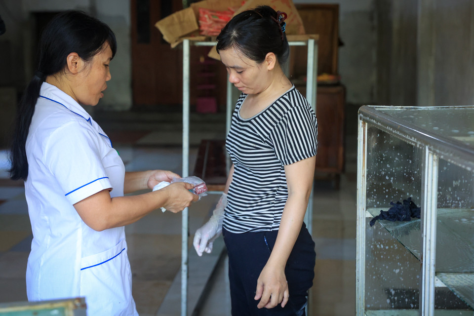 Lực lượng y tế địa phương phát thuốc, dặn dò người dân sát trùng, khử khuẩn nguồn nước và nhà ở sau trận ngập. (Ảnh: Hoài Nam/Vietnam+)