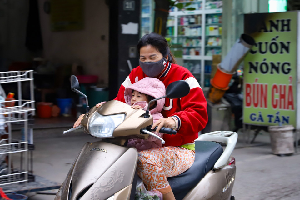 Người dân chật vật di chuyển trong thời tiết lạnh kèm gió lớn. (Ảnh: Hoài Nam/Vietnam+)