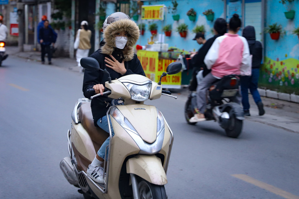 Người dân đã phải mặc những trang phục áo rét dày dặn đồng thời che kín mặt khi di chuyển trên đường. (Ảnh: Hoài Nam/Vietnam+)