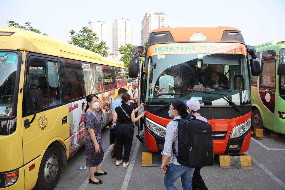 Phía cổng ra khu vực bến xe, lượng ôtô khách liên tục xuất bến. Nhiều xe tuyến huyện đã 'ken cứng' hành khách và đều được kiểm tra vé trước khi ra khỏi bến. (Ảnh: Tuấn Anh/Vietnam+)