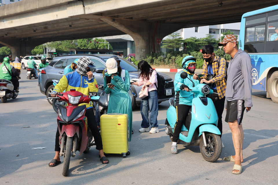 Lượng xe máy, ôtô tăng đột ngột so với ngày thường khiến tại hầu hết những điểm dừng đỗ đèn đỏ, dòng người phải di chuyển mấy nhịp đèn mới thoát khỏi ùn tắc. (Ảnh: Tuấn Anh/Vietnam+)