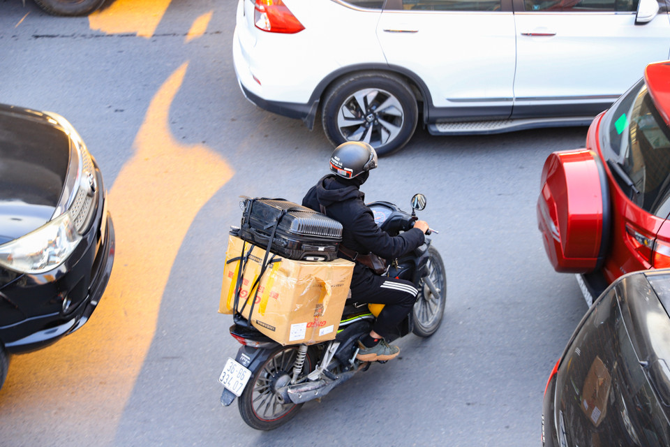 Xe máy loay hoay tìm cách thoát khỏi sự bủa vây của 3 hàng ôtô dàn ngang trên đường Nguyễn Xiển. (Ảnh: Hoài Nam/Vietnam+)